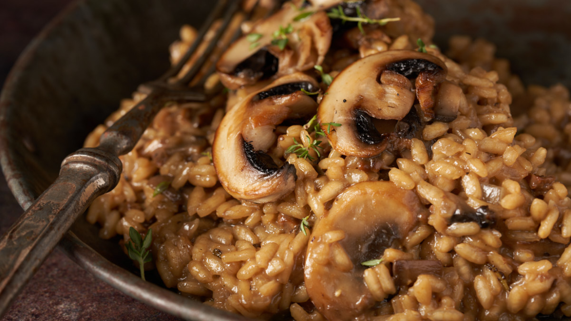 The Best All-Season Mushroom Risotto image of mushroom risotto against a dark moody background