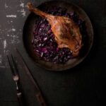 photo of St Martin's Goose with red cabbage in a dark and moody setting