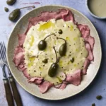 image of Vitello Tonnato, a veal dish with tuna and caper sauce from the Piedmont region in Northern Italy, served in a rustic setting