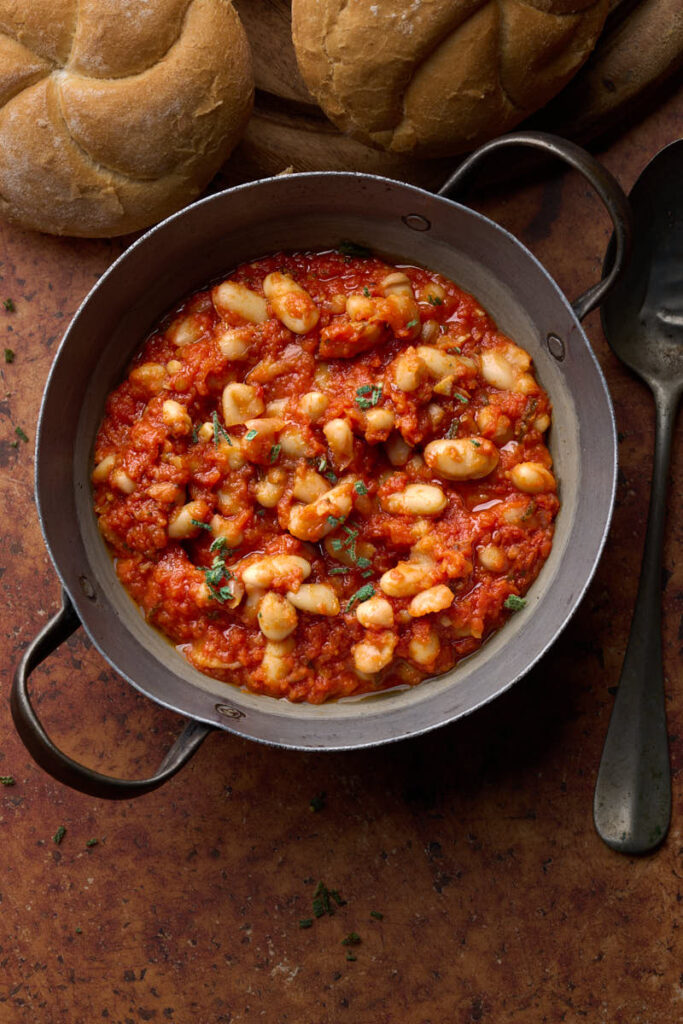 image of tuscan baked beans (Fagioli all'Uccelletto) in a rustic setting