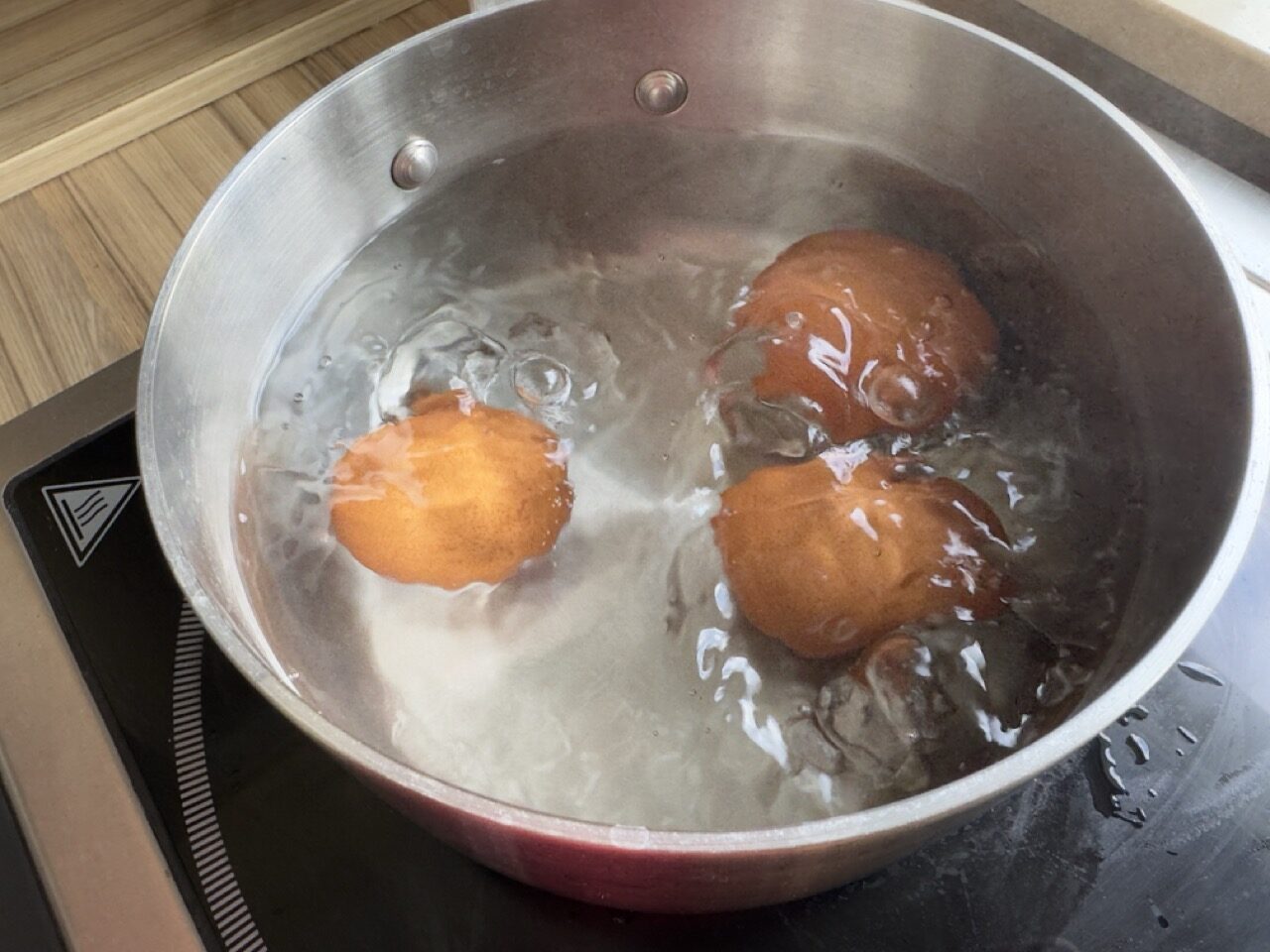 Hard boiled eggs simmering in a silver saucepan