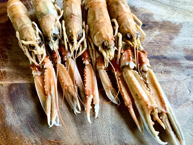 image of raw scampi on a wooden chopping board