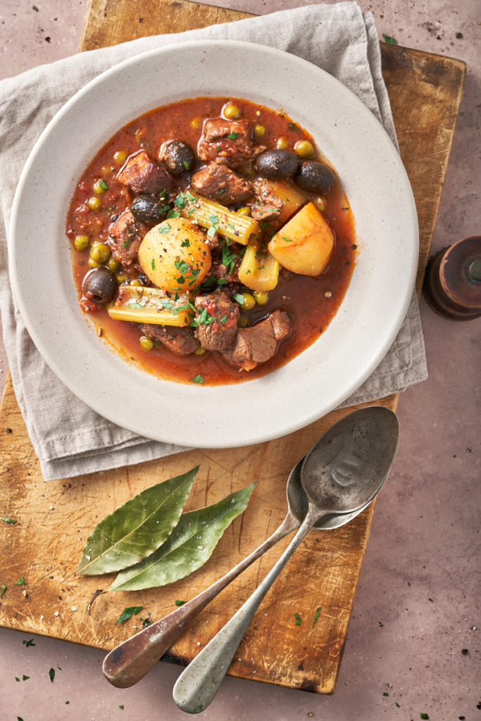 Easy Lamb Stracotto with Orange and Olives photo of lamb stracotto with oranges and olives from Italy's Puglia iregion n a rustic Italian setting