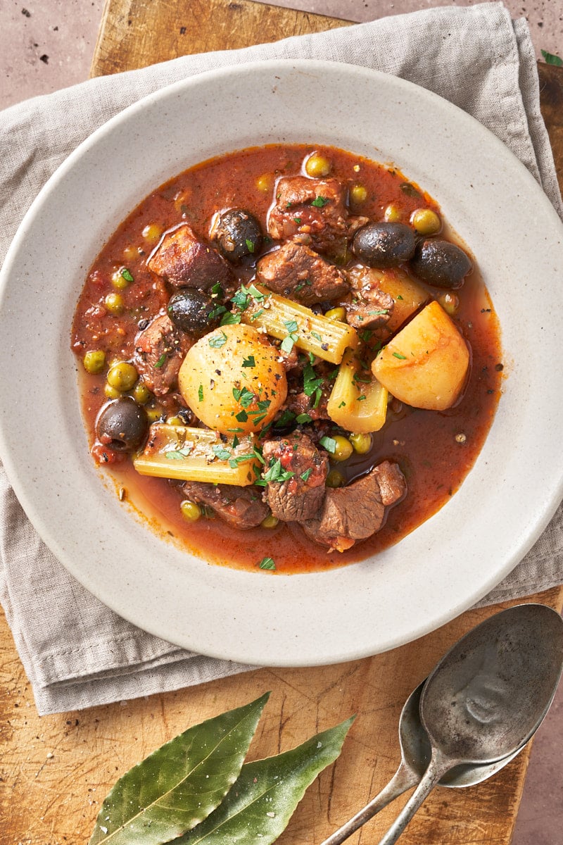 photo of lamb stracotto with oranges and olives from Italy's Puglia iregion n a rustic Italian setting