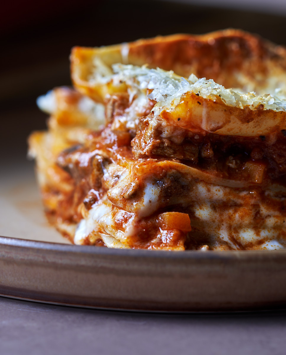 image of vincisgrassi, a rustic lasagne from Italy's Marche region, shot from side on showing all the layers of the lasagne