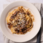 image of ragu alla marchigiana, a Marche region meat sauce served in an off white bowl with Maccheroncini di Campofilone