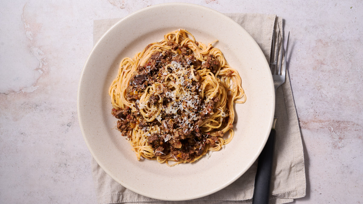 image of ragu alla marchigiana, a Marche region meat sauce served in an off white bowl with Maccheroncini di Campofilone