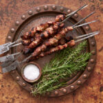 image of Arrosticini on metal skewers with rosemary