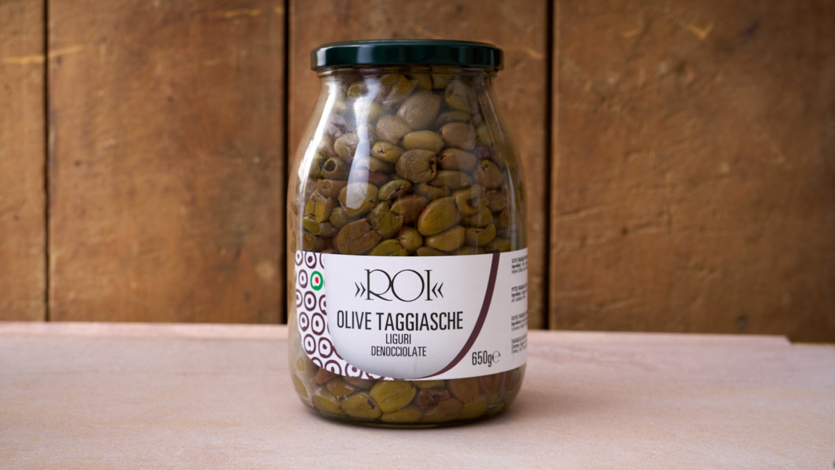 image of a jar of Taggiasca olives against a wooden background